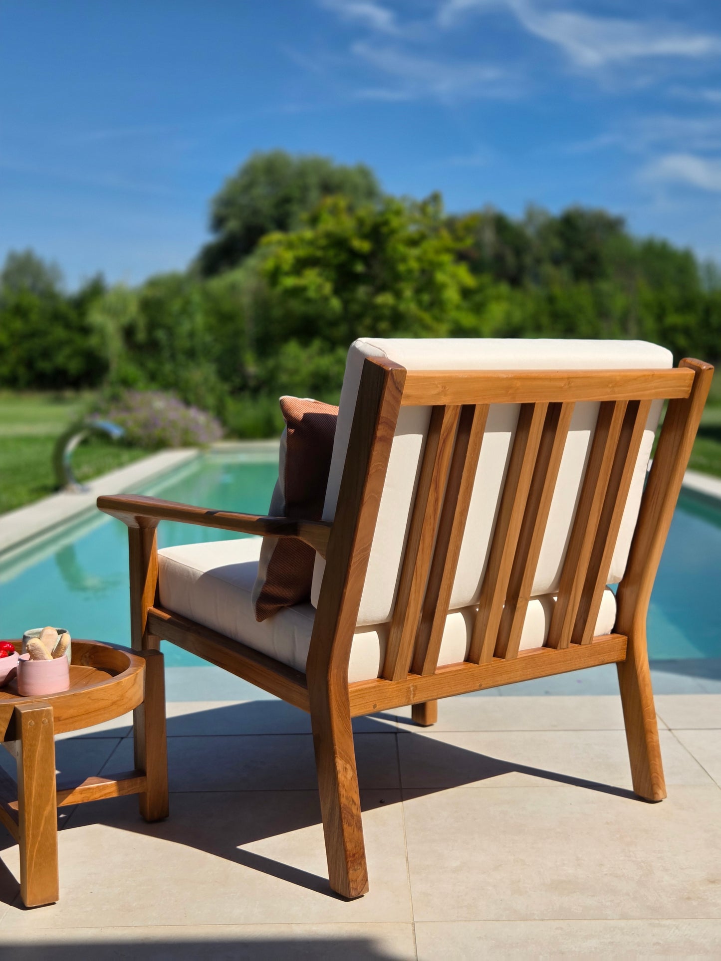 Premium Grade A teak lounge chair with weather-resistant ivory cushions for luxury outdoor mediterranean living.