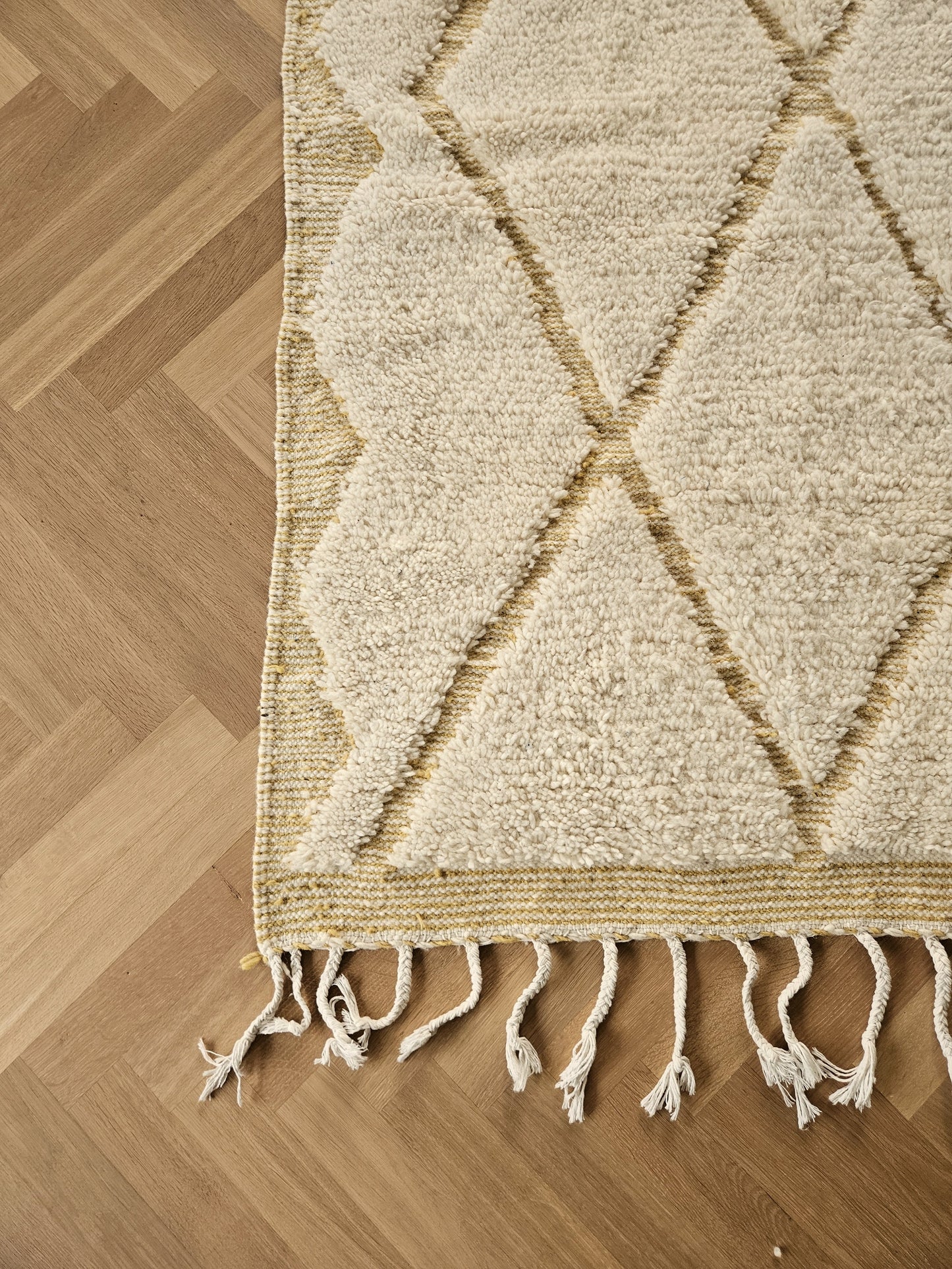 Close-up of authentic Beni Ouarain rug in natural wool with sand-toned diamond pattern.