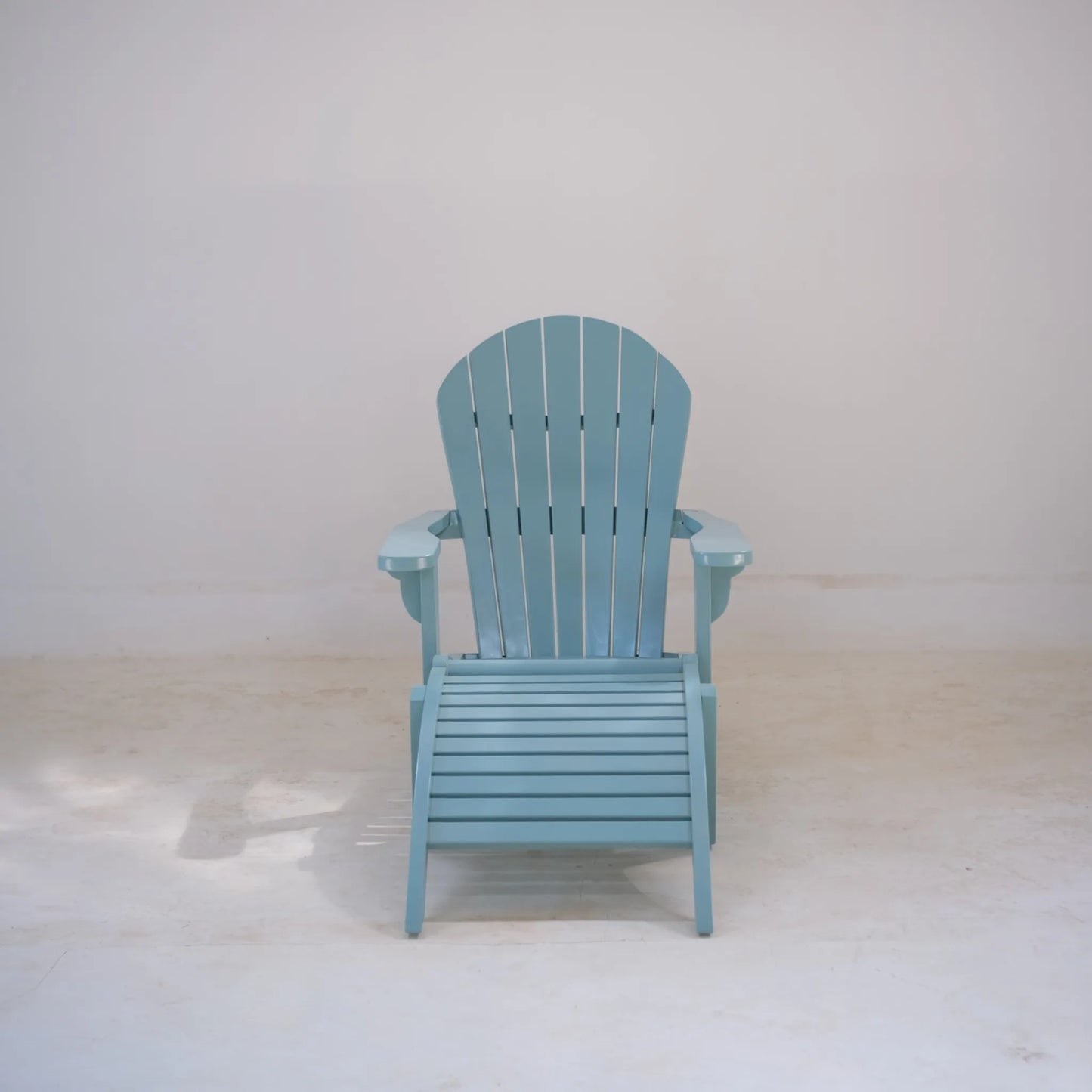 Front-facing pastel blue Adirondack chair with footrest photographed in a bright studio setting.