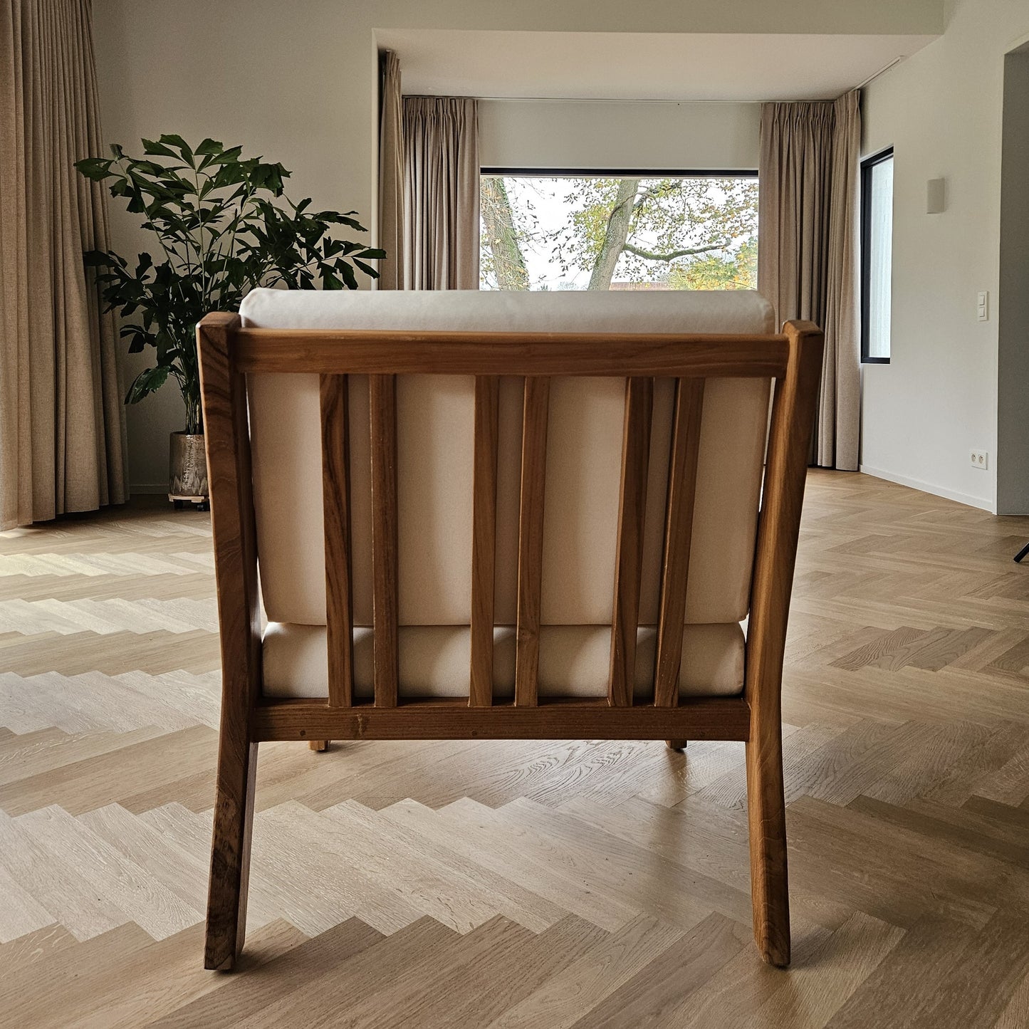 “Back view of the Matala lounge chair showcasing a solid teak frame with vertical slats.”