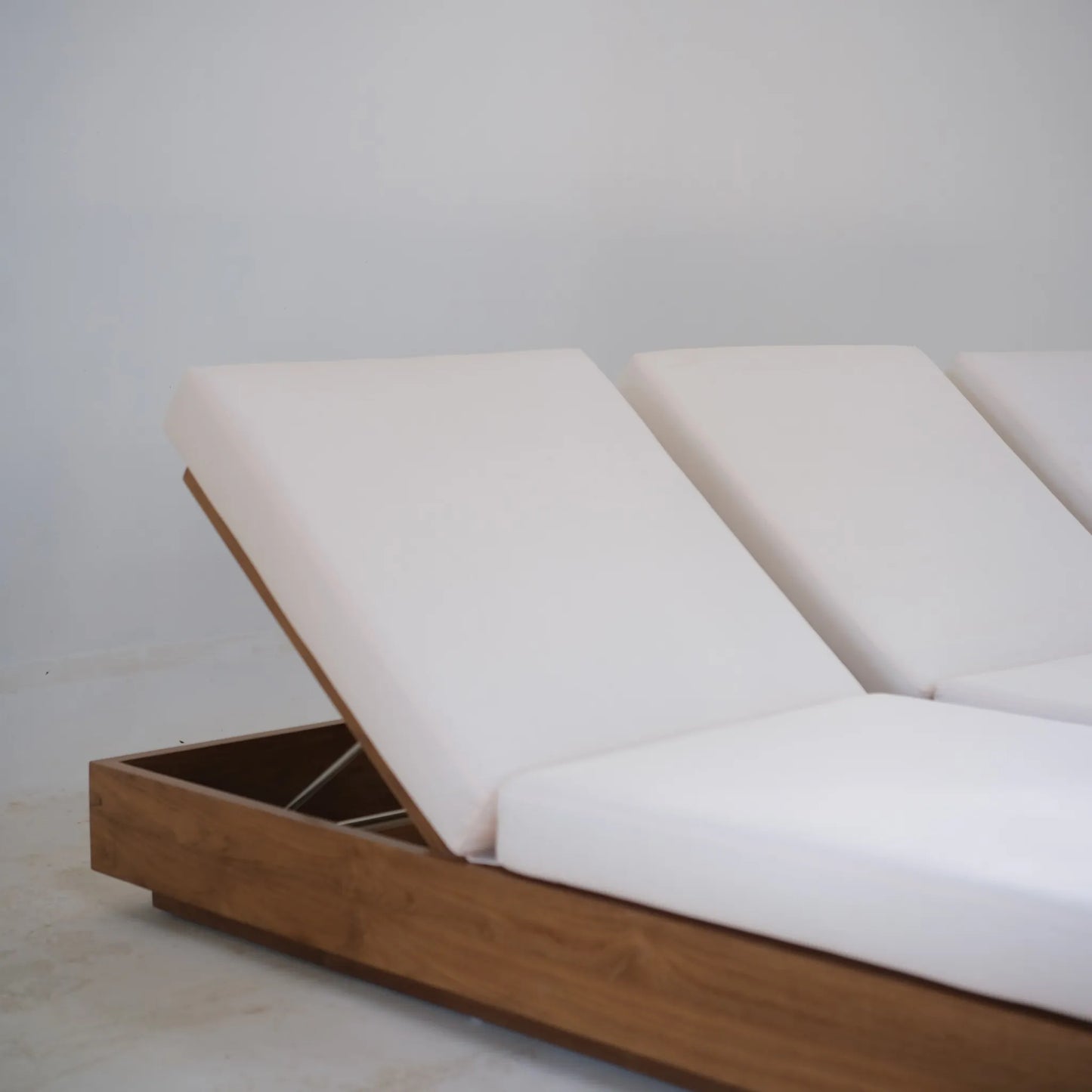 Close-up of the adjustable white cushion on the teak Laguna Sun Bed in a bright studio setting.