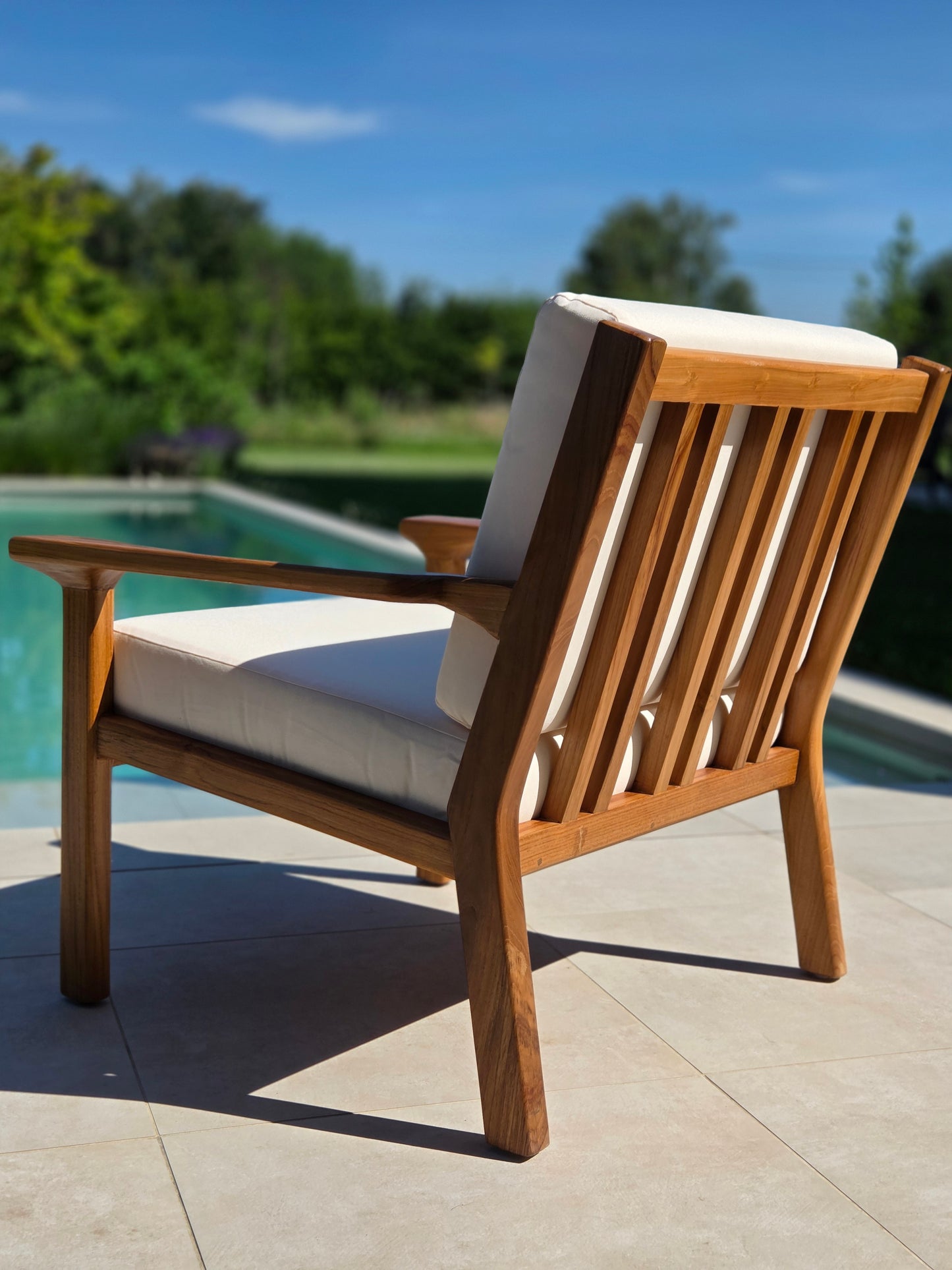 Premium Grade A teak lounge chair with weather-resistant ivory cushions for luxury outdoor mediterranean living.