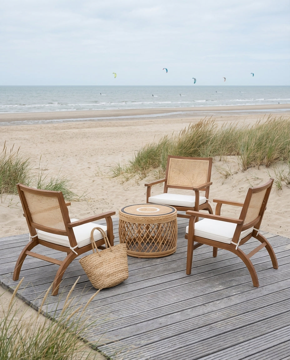 Teak wood lounge chairs with woven seats on a sandy beach, coastal boho outdoor setting with natural materials and sea view