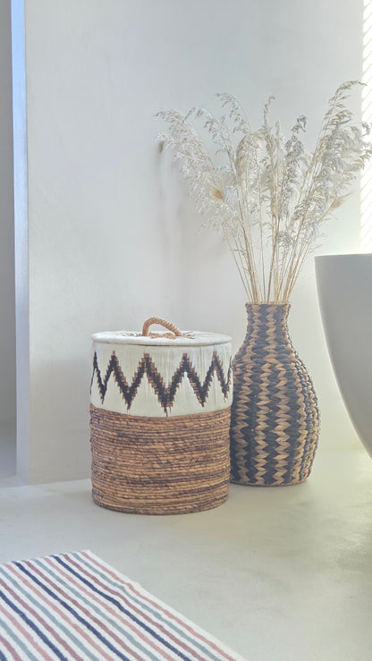 Samuel natural abaca storage basket with lid and white and black zigzag pattern in a boho bathroom.