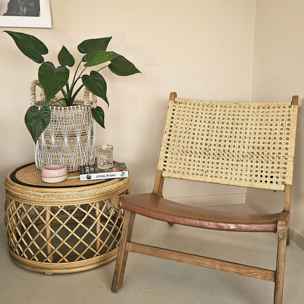 Gevlochten rotan bijzettafel, gestyled met verse aardbeien, naast een Grade A teak lounge stoel met uitzicht op een mediterraan zwembad.
