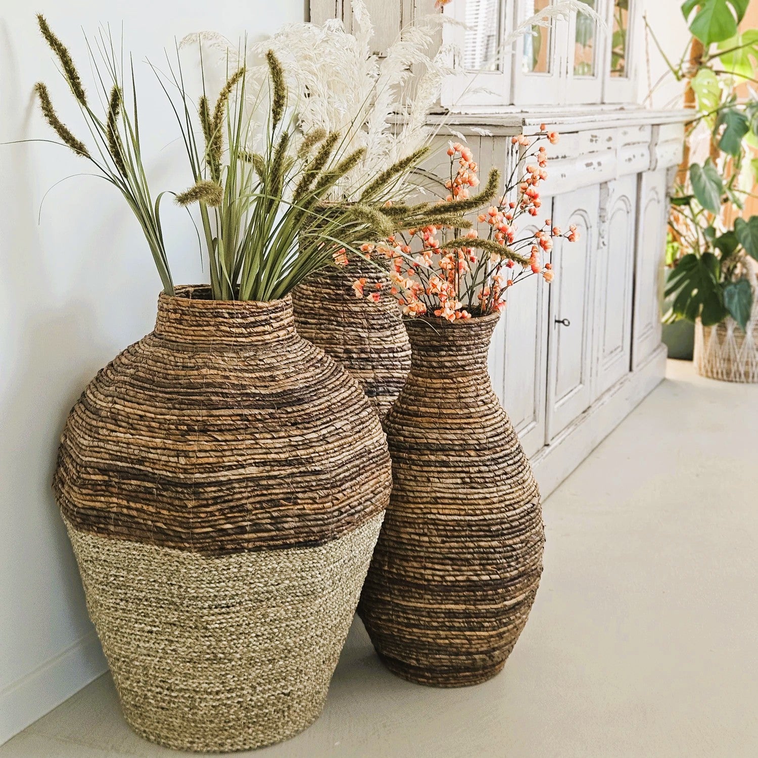 Vasi da pavimento in abaca fatti a mano, decorati con fiori secchi in un interno naturale boho. Decorazioni per la casa artigianali e sostenibili di Vibes del Mundo.