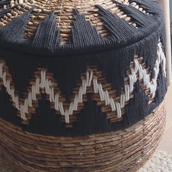 Close-up video of the Samuel Black handwoven abaca storage basket, highlighting its natural woven texture, distinctive black and white zigzag pattern and fitted lid with decorative handle. A stylish storage solution for bohemian and contemporary interiors.