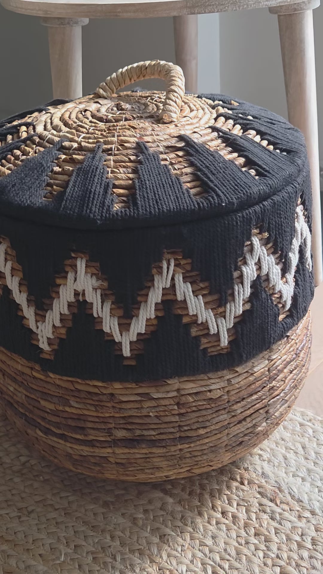 Close-up video of the Samuel Black handwoven abaca storage basket, highlighting its natural woven texture, distinctive black and white zigzag pattern and fitted lid with decorative handle. A stylish storage solution for bohemian and contemporary interiors.